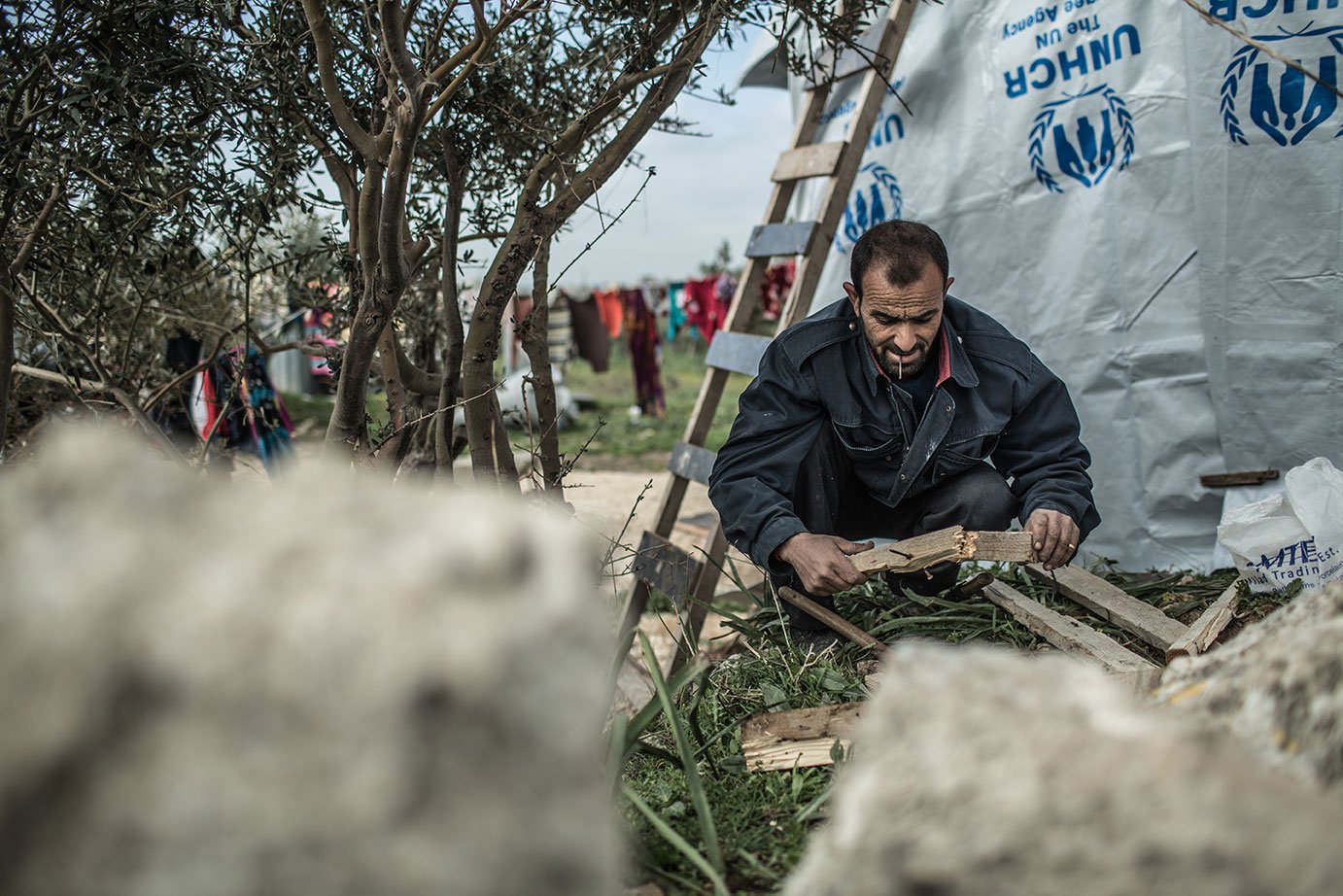 A Syrian man builds a shelter out of tarps and other material in Lebanon. Fighting has forced millions of Syrians to flee their country.