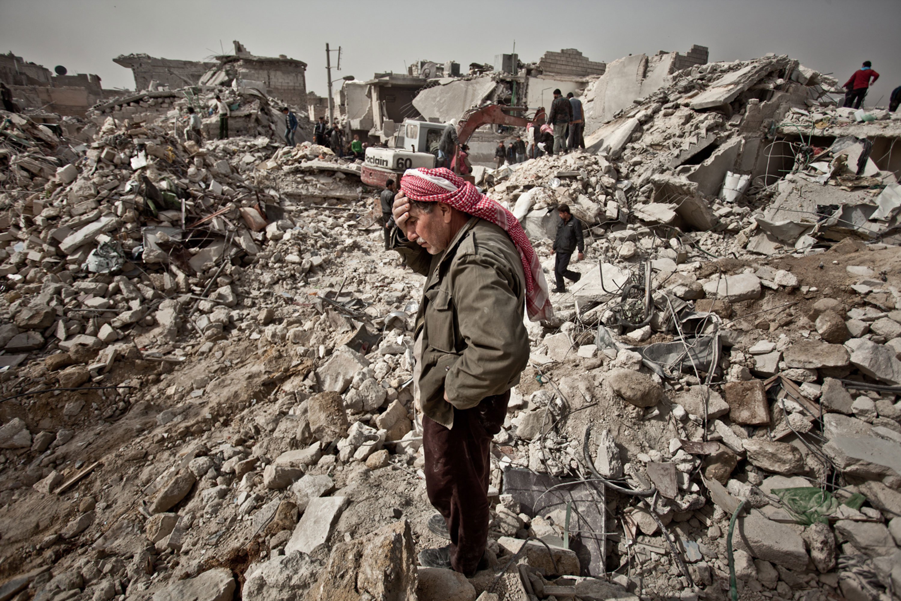 A man stands amid rubble in the city of Aleppo, Syria. More than six years of fighting has destroyed communities and killed half a million people.