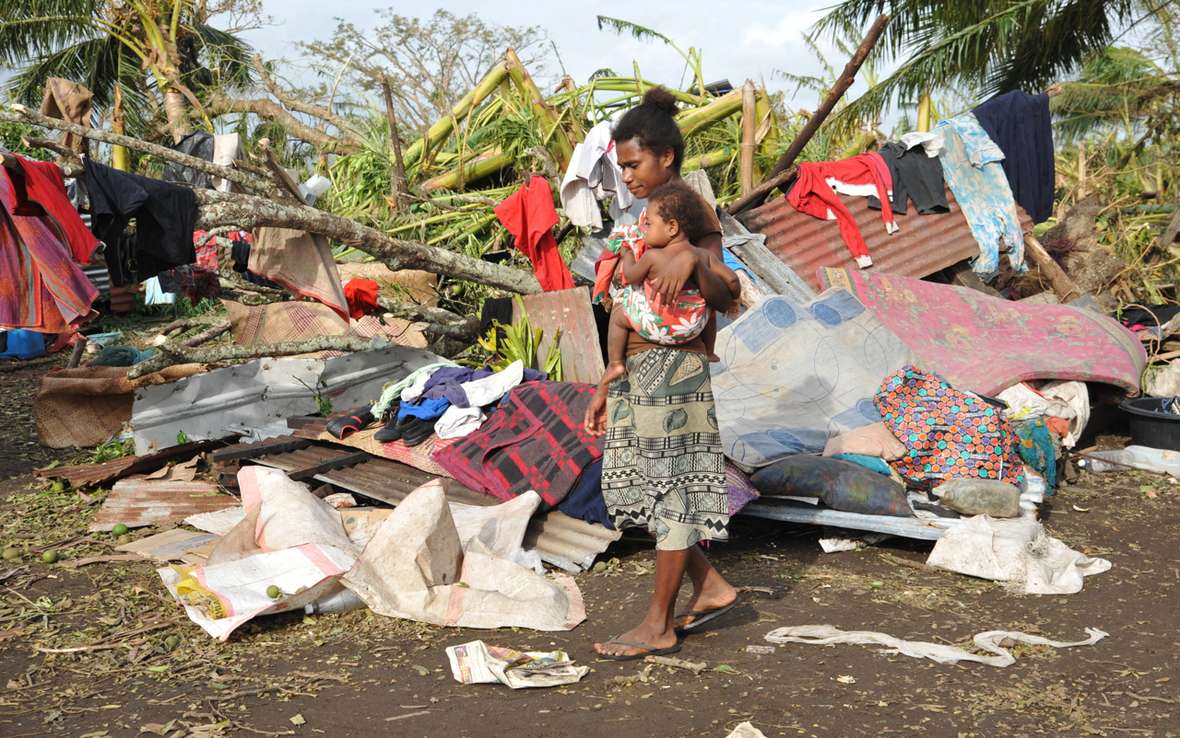 Woam carrying child through wreckage 78504.jpg