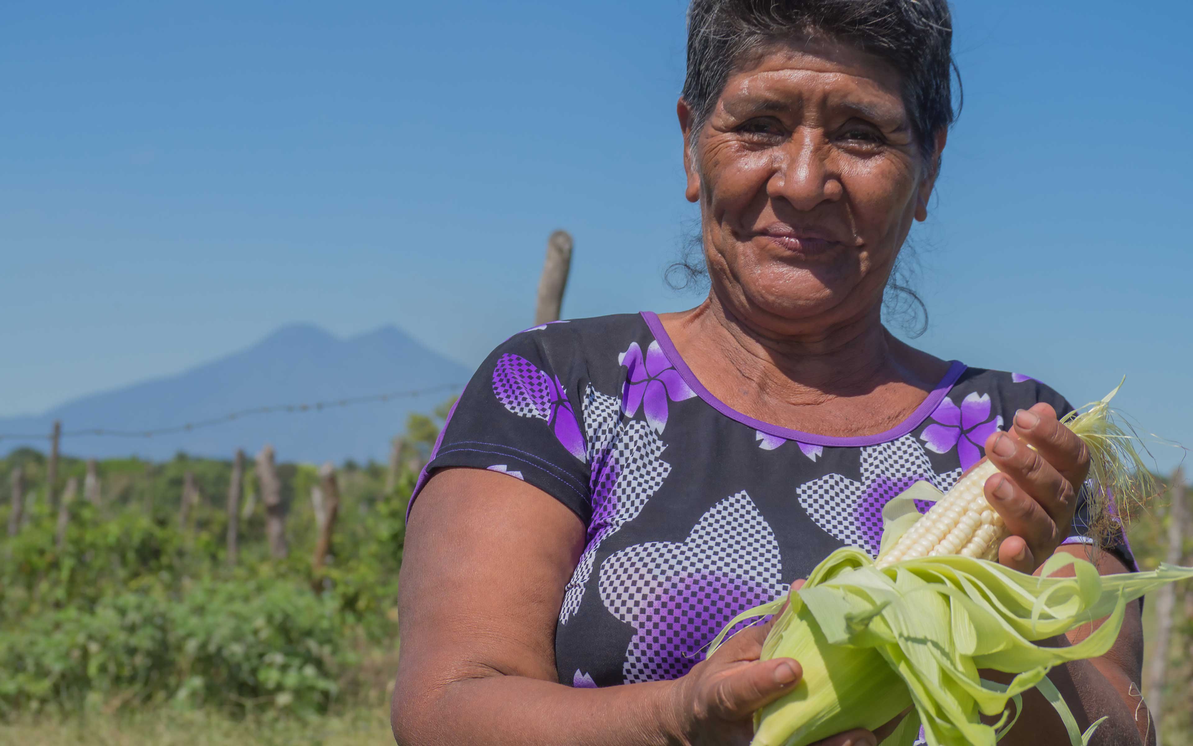 Flor Aquino displays corn grown on a community plot in El Ranchón. While the country is reeling from the effects of El Niño, corn and beans are thriving here.