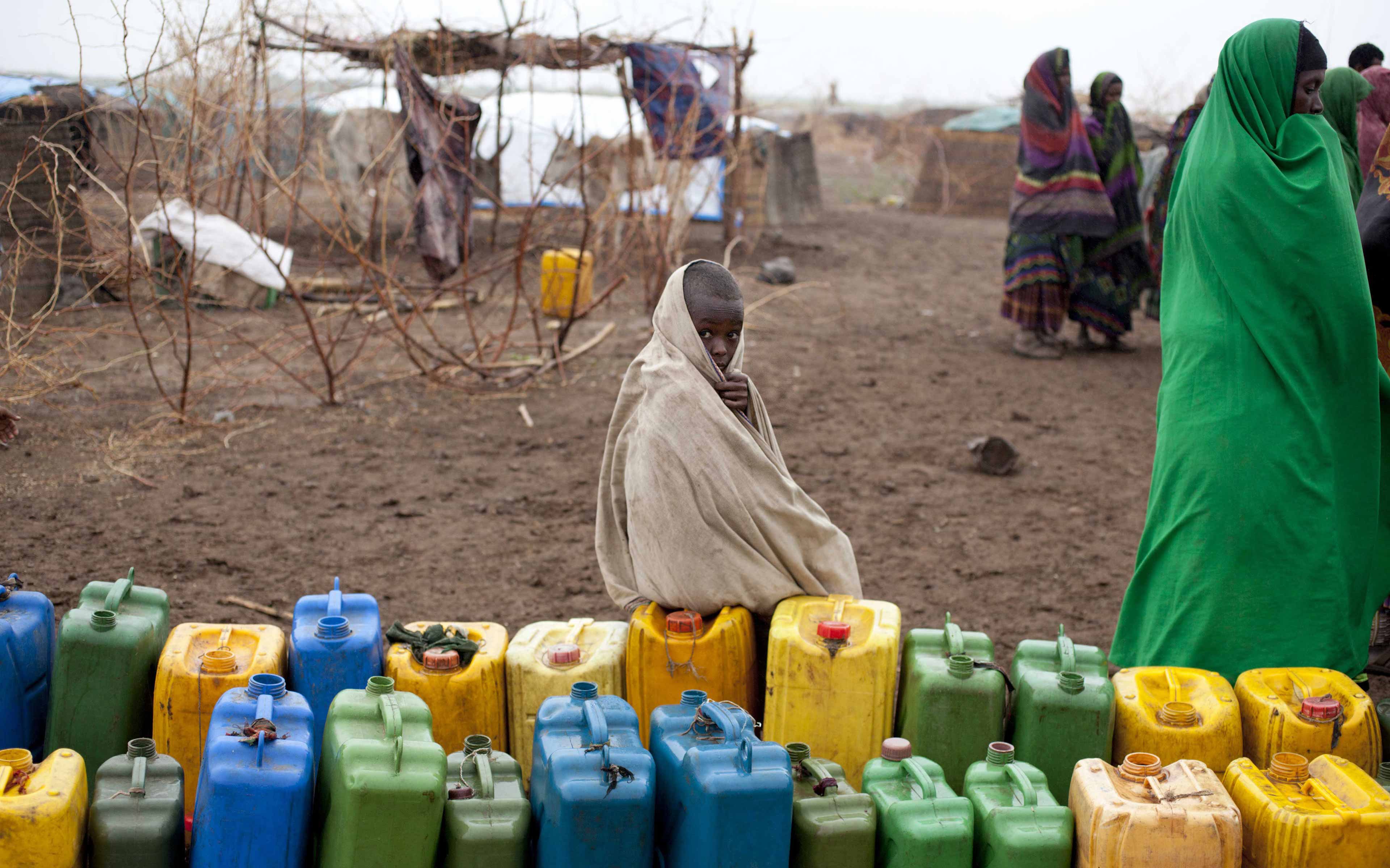 In the Siti Zone of Ethiopia’s Somali region, a boy waits next to a collection of water jugs lined up to be filled with water trucked in by Oxfam and stored in a tank.