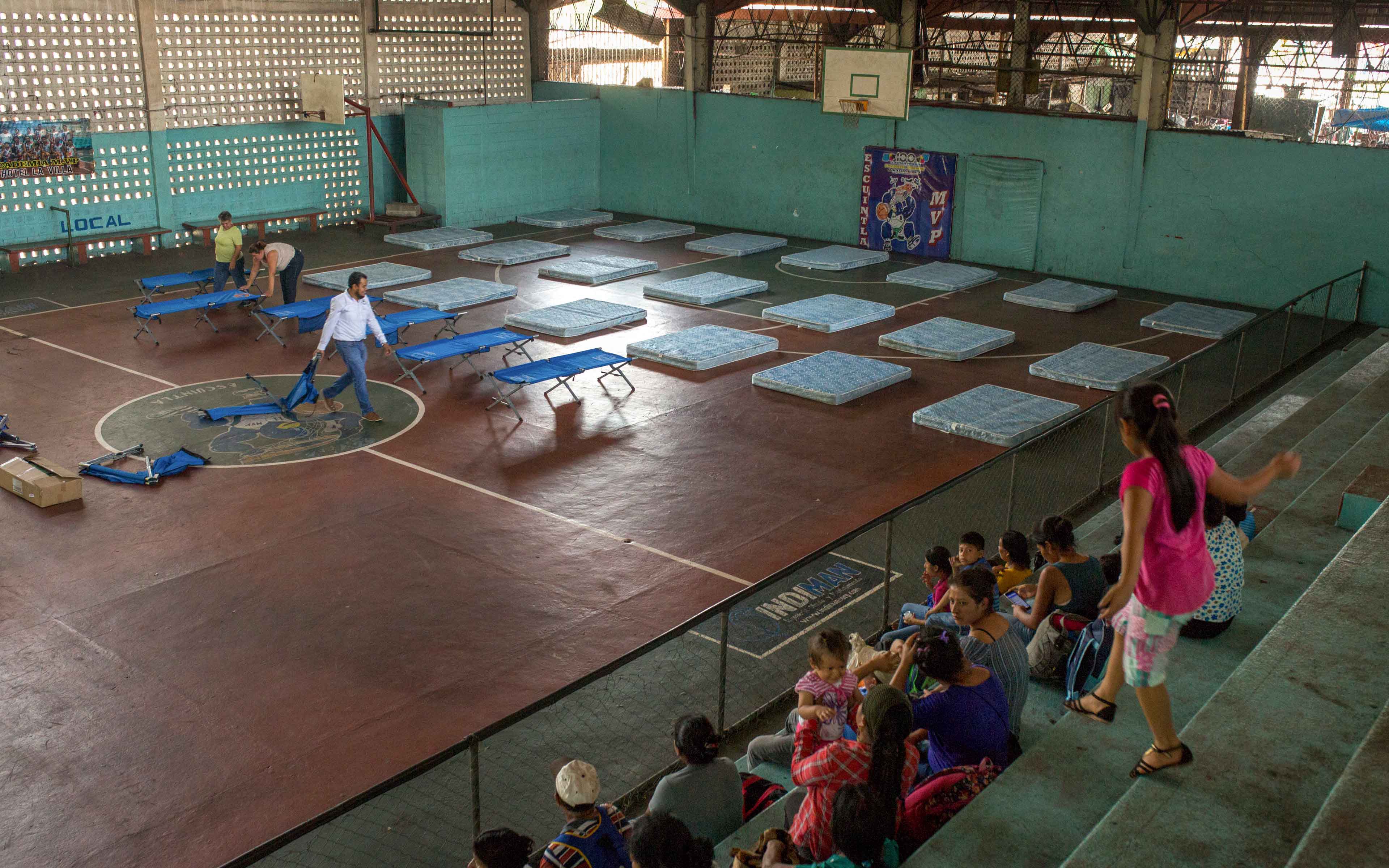 Families from La Trinidad wait to be assigned a place in the municipal gymnasium in Escuintla.