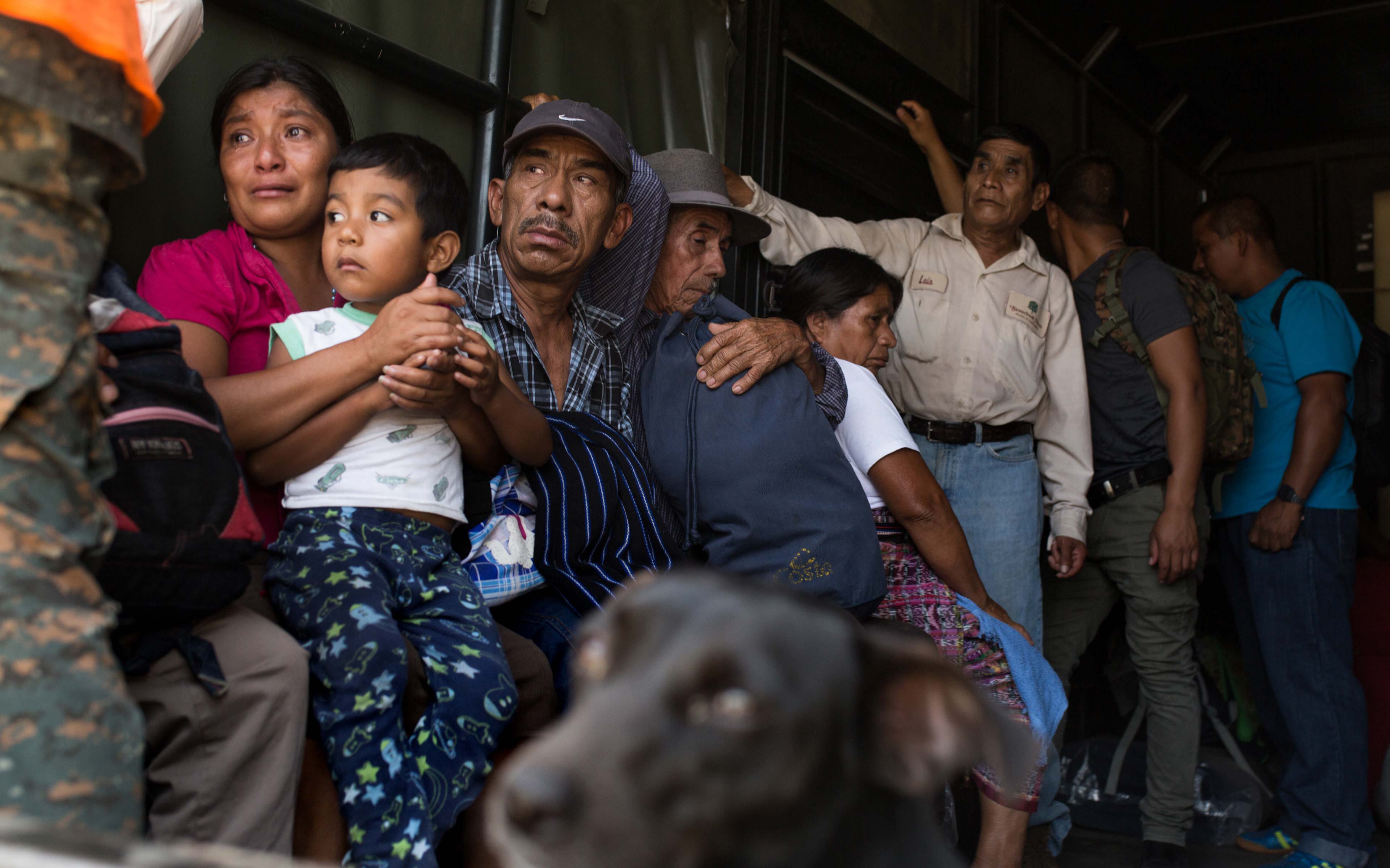 Abi Hernandez holds her 4-year-old son Rodrigo in the back of a Guatemala Army truck as she and her neighbors are evacuated from La Trinidad, on the southern slope of the Fuego Volcano.