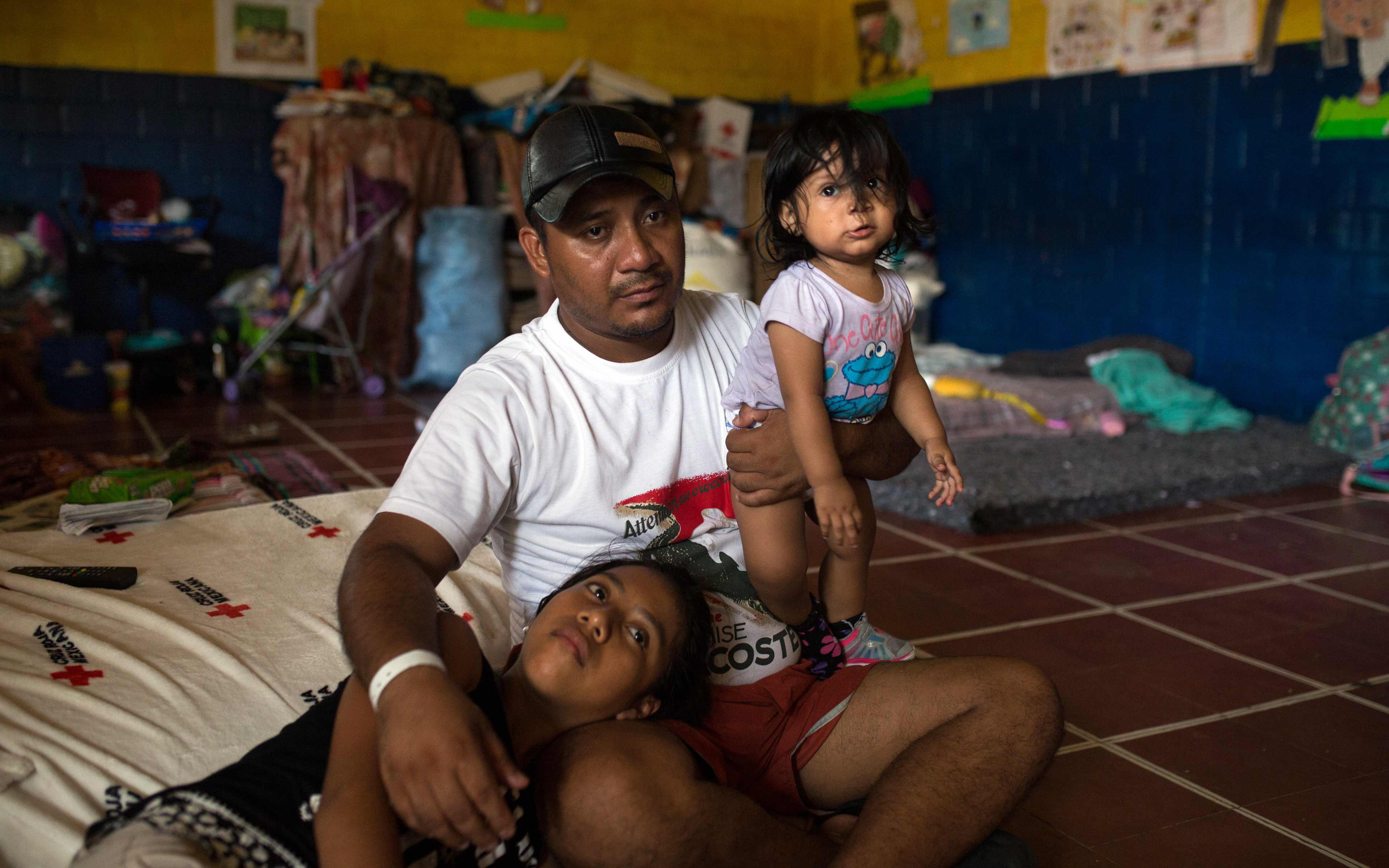 Edwin López and his daughters Melanie (11) and Masiel (1), in the classroom where they are living temporarily.