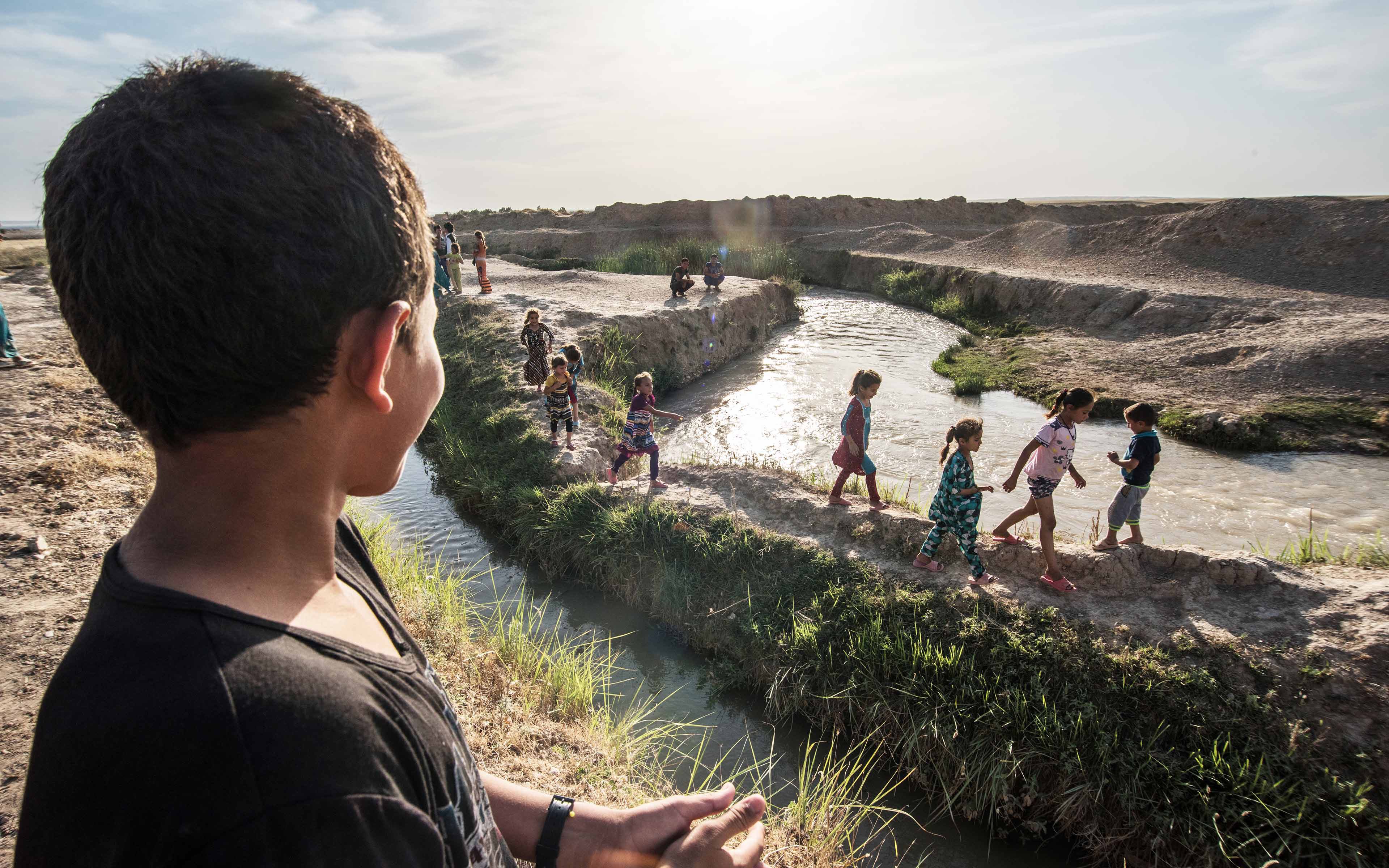 Forced from their homes when ISIS occupied their neighborhoods, these Iraqi children have found a new place to play near an abandoned farm building where some of their families now live.