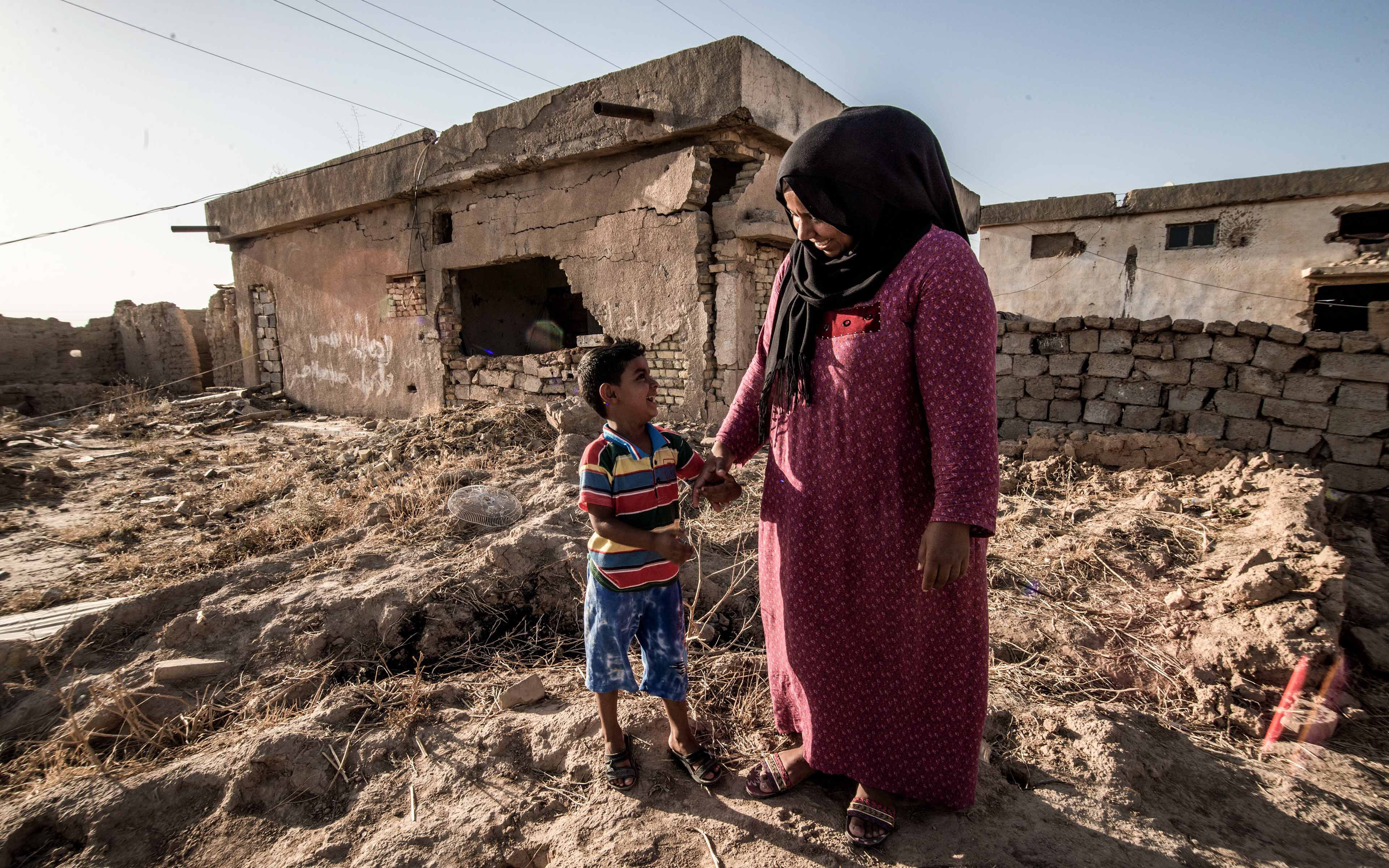 Zahia Hassan, whose name has been changed to protect her identity, talks with her 4-year-old son. The small family has returned to their Iraqi village after it was reclaimed from ISIS.