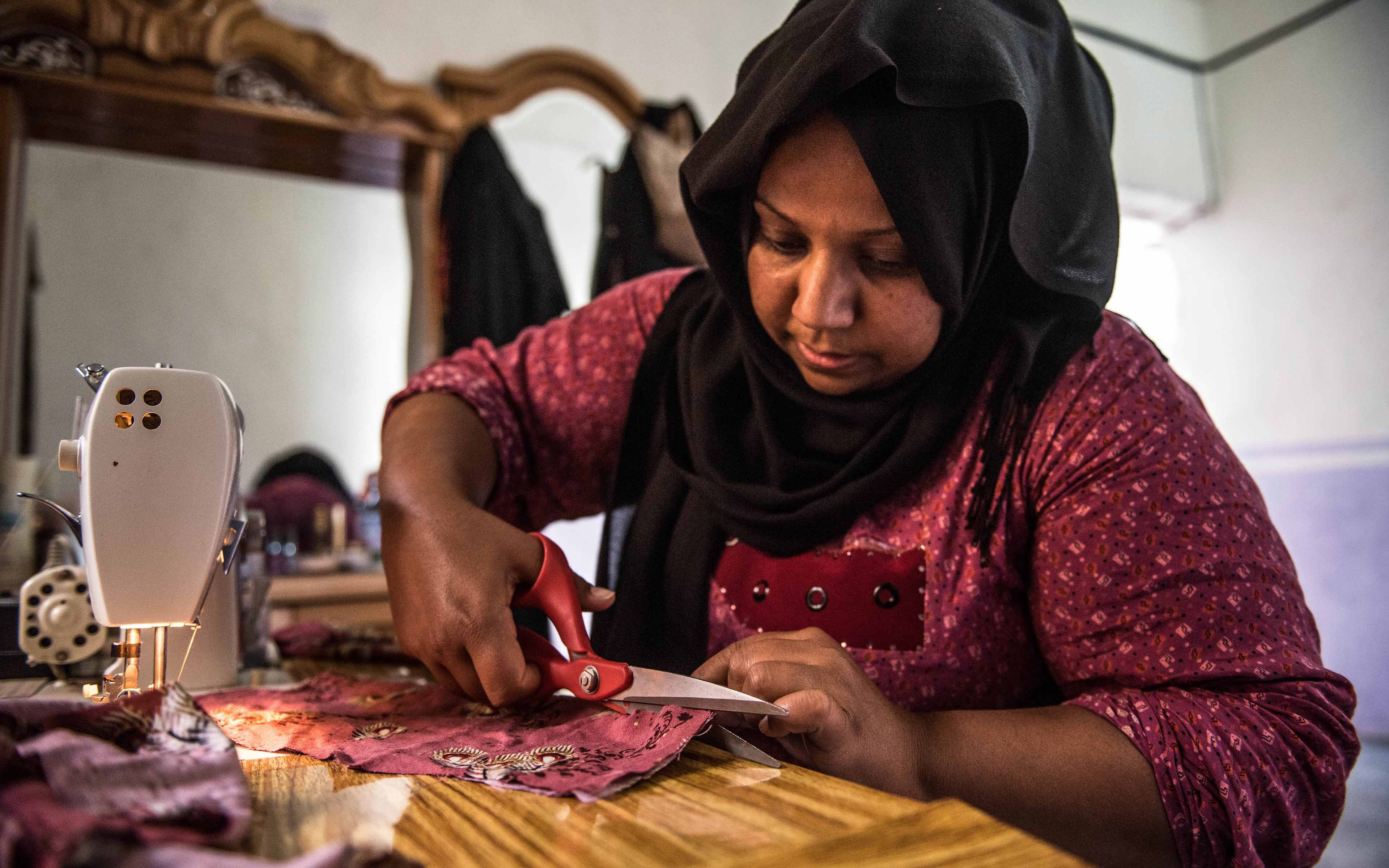 Zahia Hassan works at her sewing machine. After the occupation by ISIS ended, Hassan, whose name has been changed to protect her identity, returned to her community and, with Oxfam’s help, has been striving to rebuild her business as a tailor for her village.
