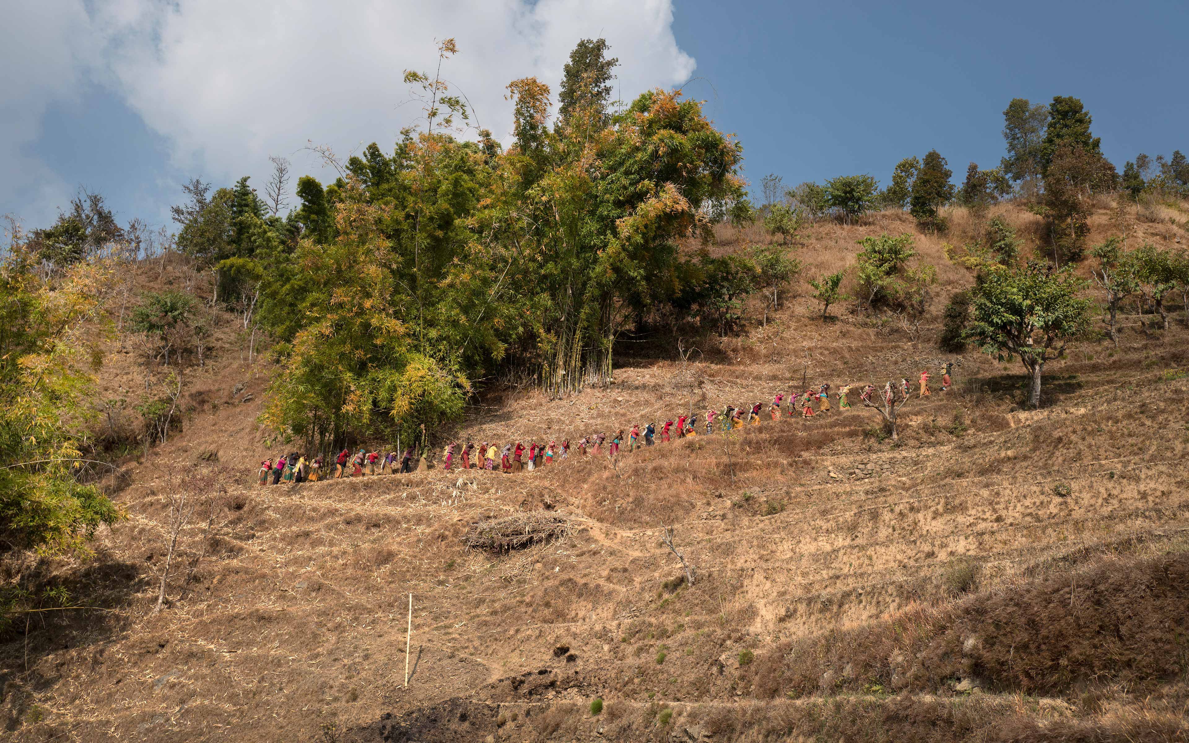 Villagers make their way along a steep slope as they work to rebuild a trail connecting two small communities, one of which lost half its houses in the 2015 earthquake in Nepal. The villagers were engaged in the project for 32 days.