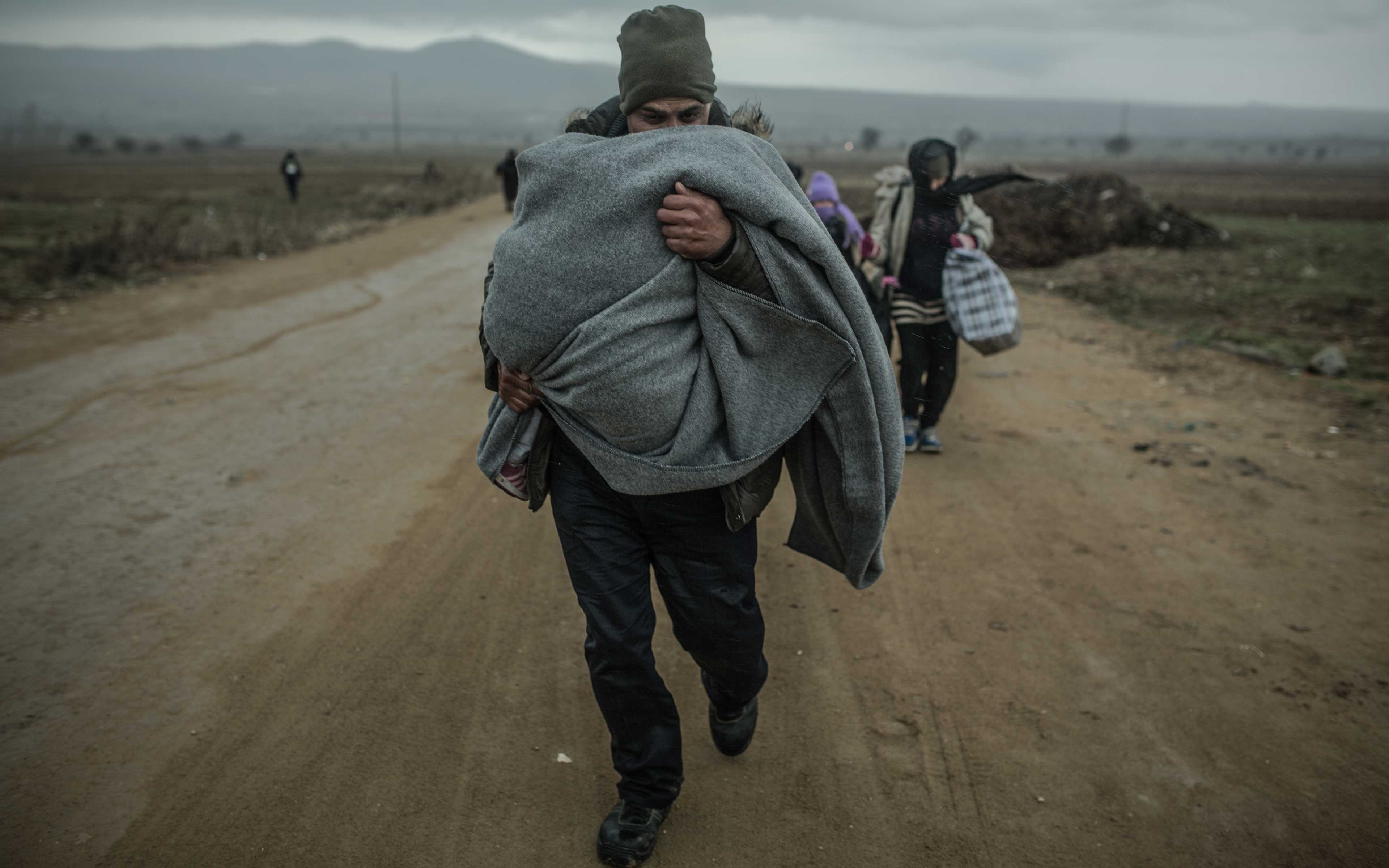 Khaled and his wife and children make their way through the cold and rain
at Macedonia’s border with Serbia in February 2016. At the time,
thousands of people a day—from Syria and other war-torn places—were passing into Serbia, where they had 72 hours to cross the country.